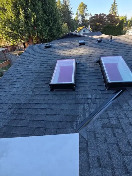 Dual skylights on charcoal shingle roof valley in Bothell
