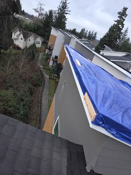 Overhead view of blue tarp on a low-slope roof section