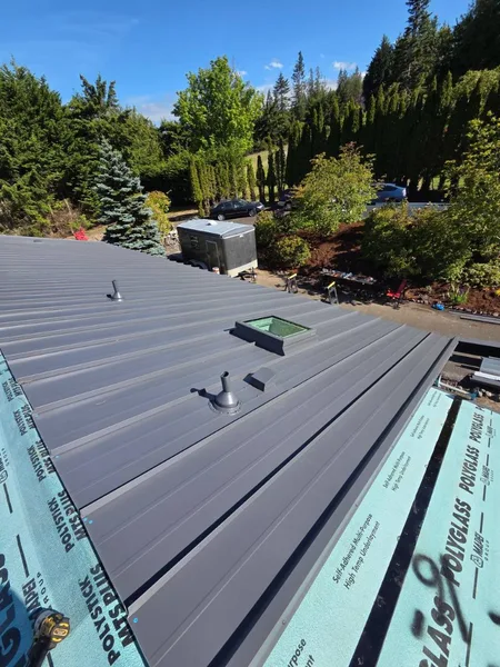 Professional standing seam metal roof installation with safety anchors
