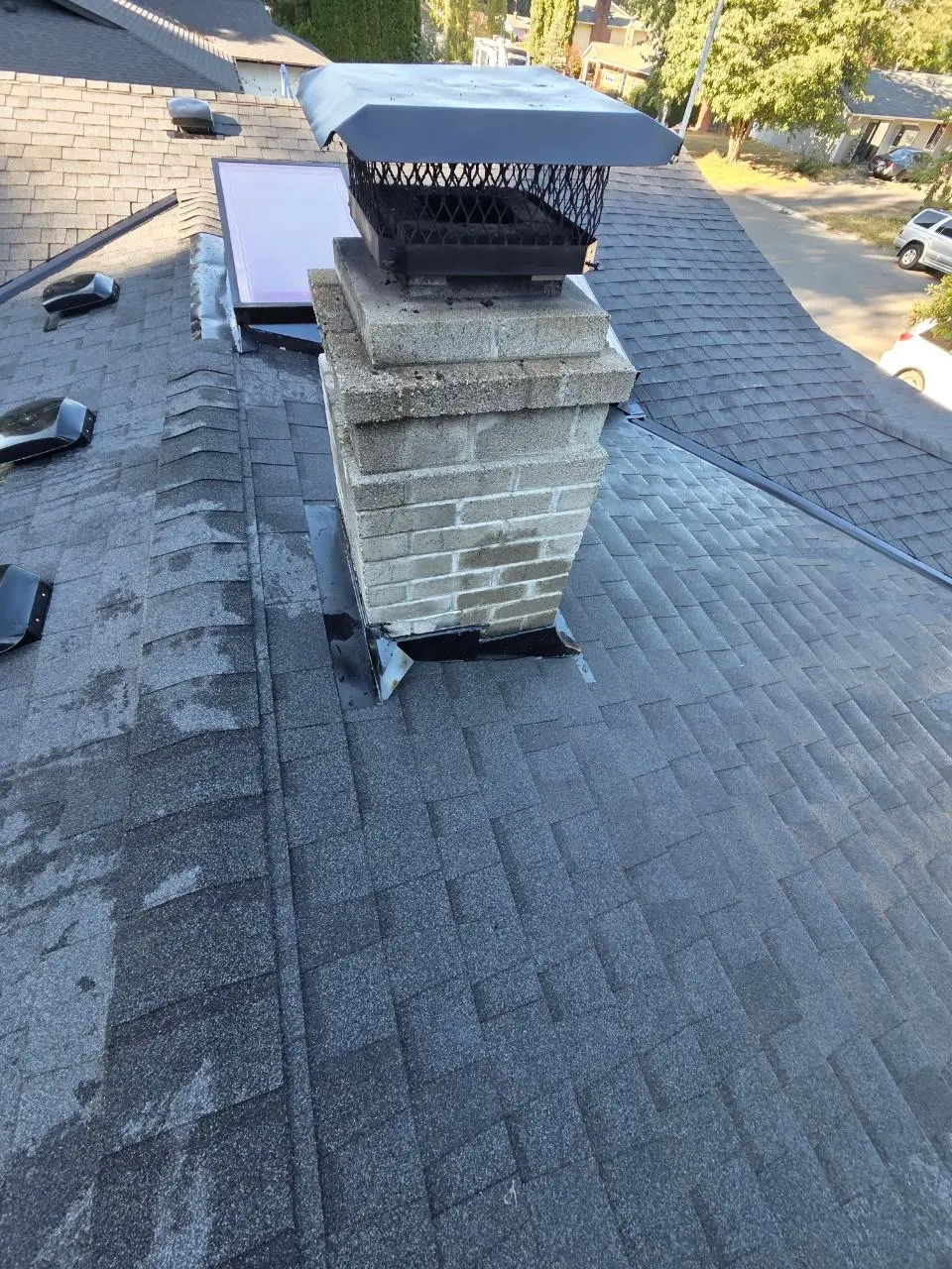 Chimney flashing and skylight on shingle roof in Seattle