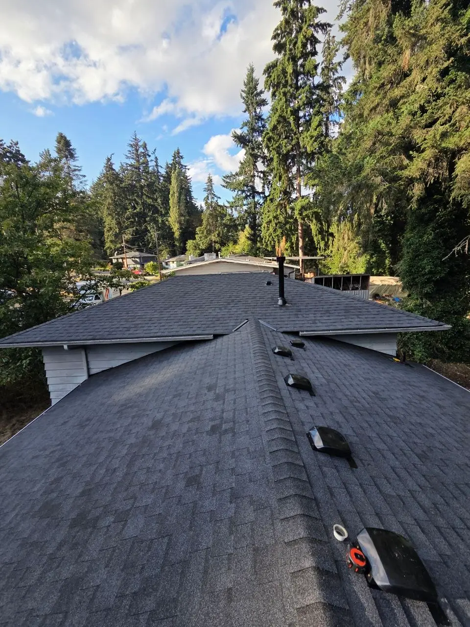 Completed charcoal shingle roof complex ridges vents