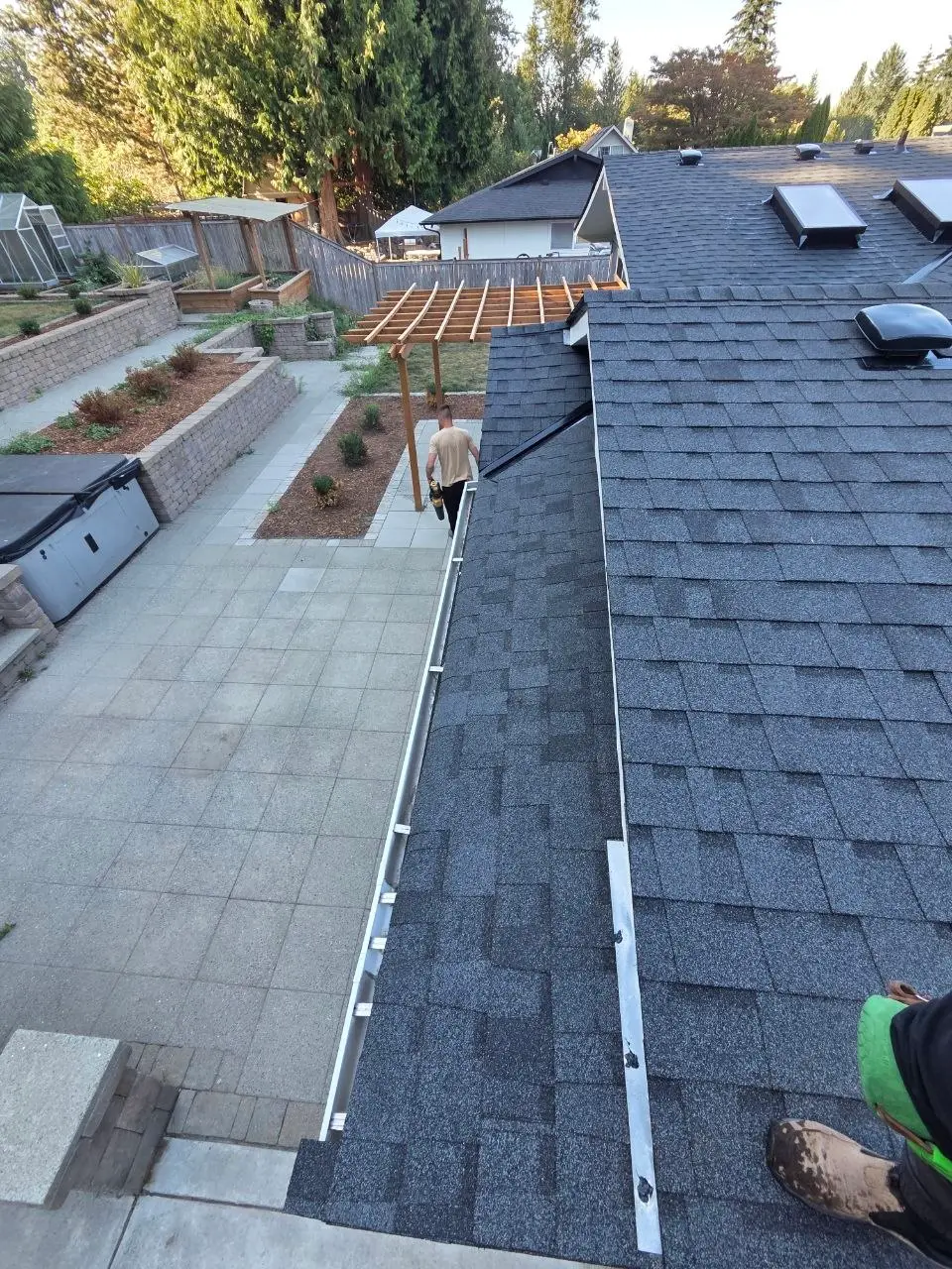 New aluminum gutter on a charcoal shingle roof edge