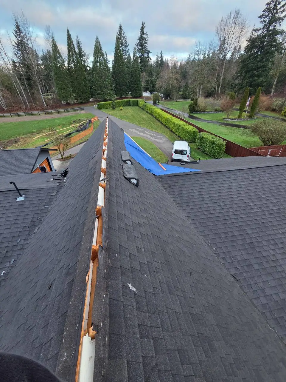 Ridge work with exposed deck and charcoal shingles