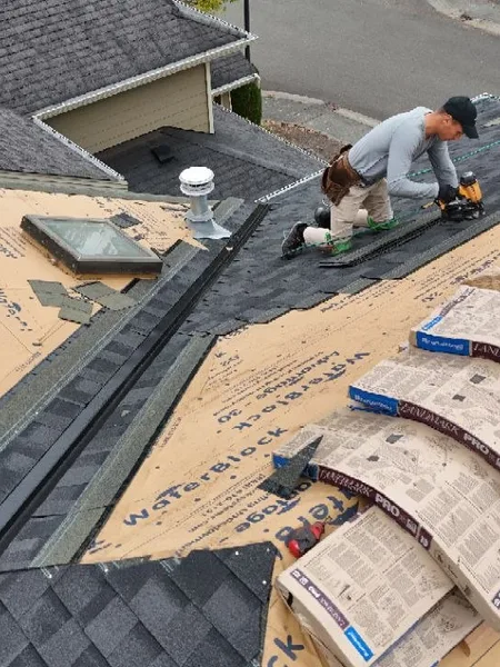 Crew fastening architectural shingle courses on a residential install