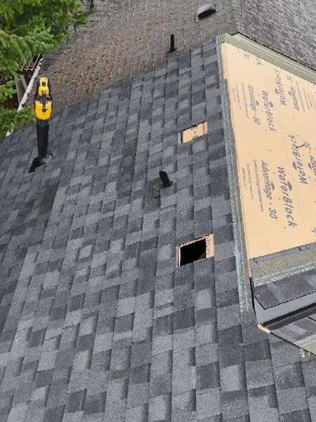 Roofer working on open deck during shingle roof replacement