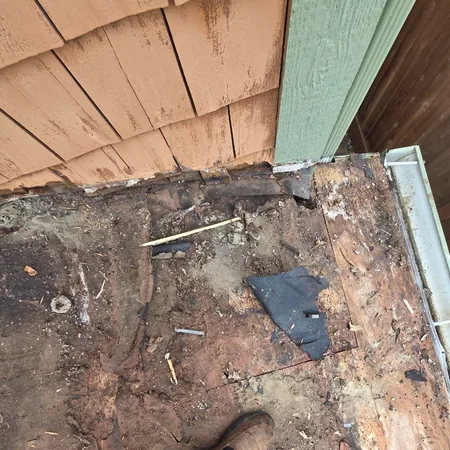 Rotted decking at the base of a wall