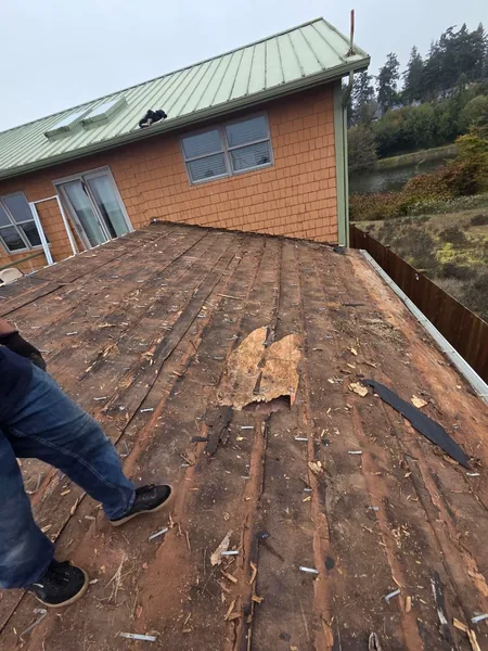 Soft spot and hole in the roof deck beside a wall