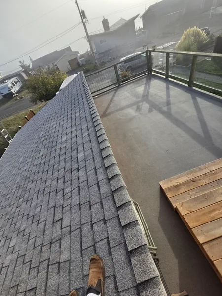 New gray shingles beside a low-slope roof section
